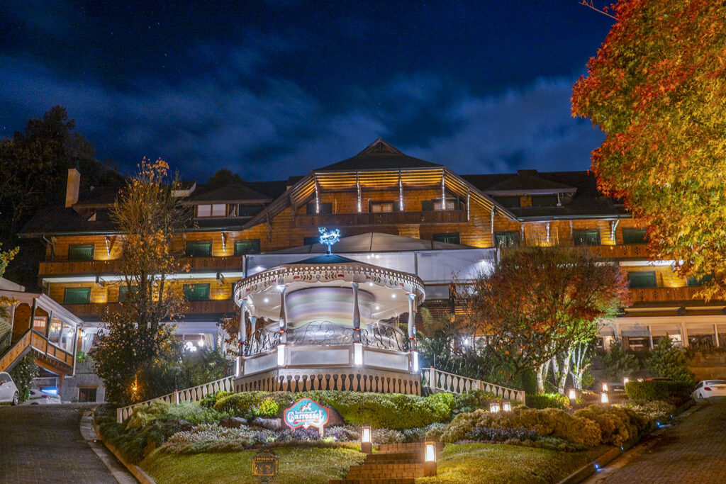 Imagem noturna com a fachada do hotel casa da montanha