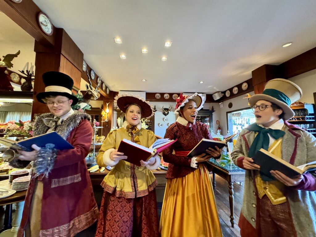 Pessoas fantasiadas de Natal cantando no natal no Casa da Montanha